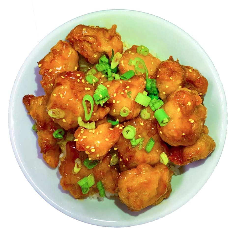 Aroma Ramen's Korean fried chicken, glazed with sauce, sesame seeds, and green onions.